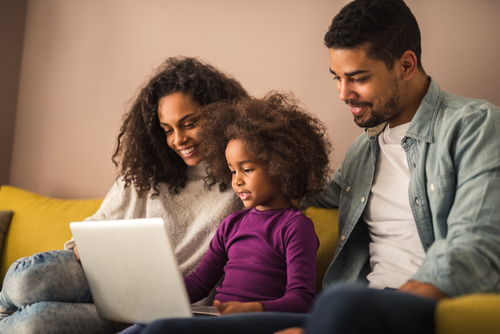 African American family watches a FREE seminar on their laptop together.
